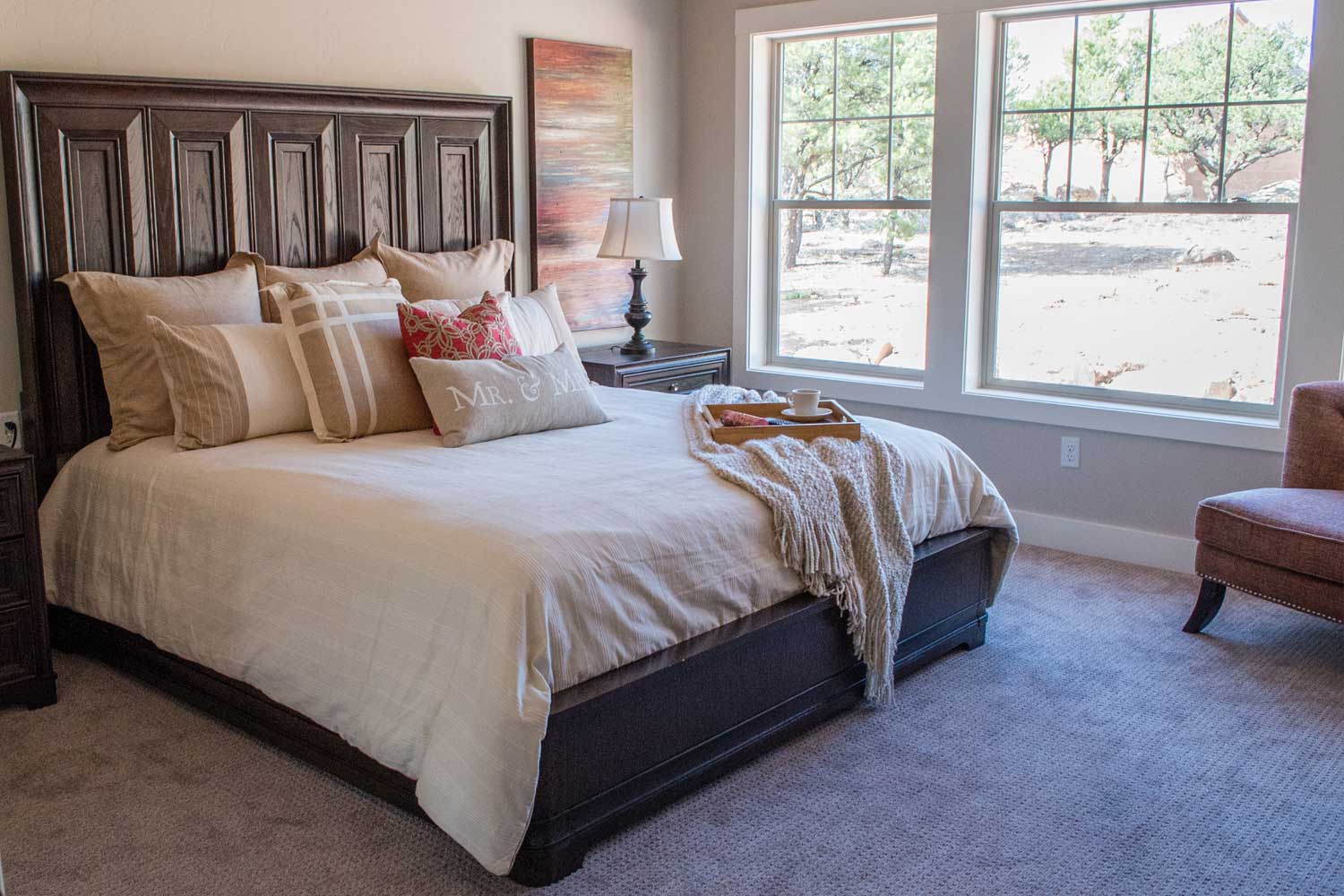 master bedroom with king size bed, side tables, and window view into backyard