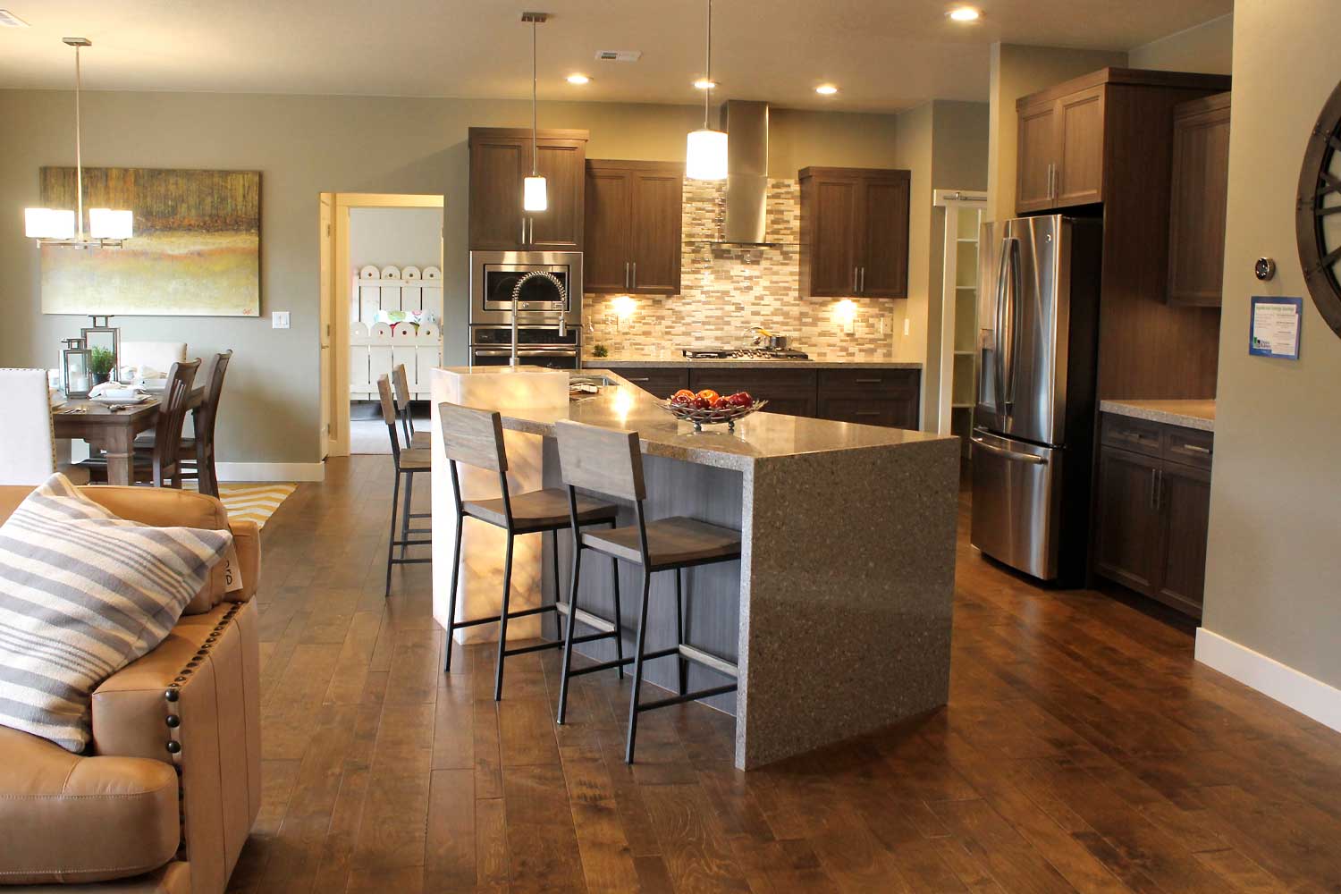 kitchen counter with two bar stools, hard wood flooring, ceiling lights