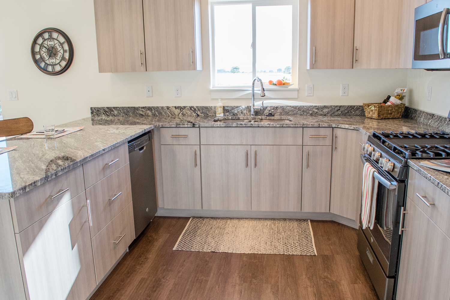 kitchen sink, granite counter tops, and light brown cabinets