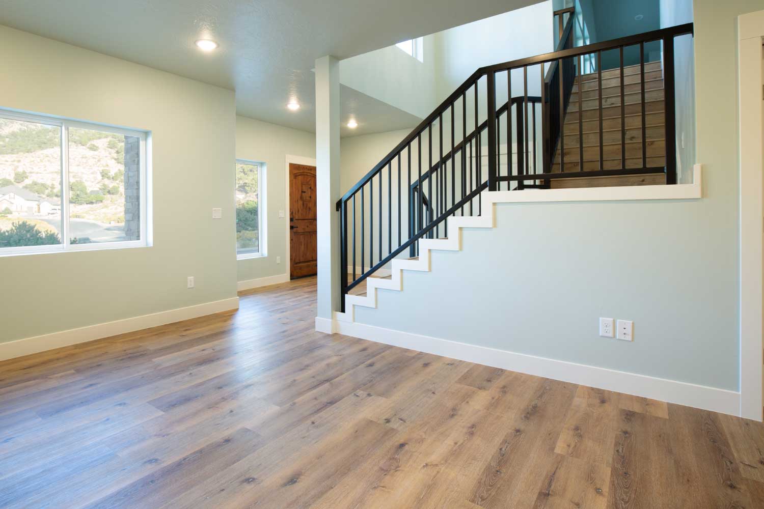 Hardwood floors and staircase with black iron railings