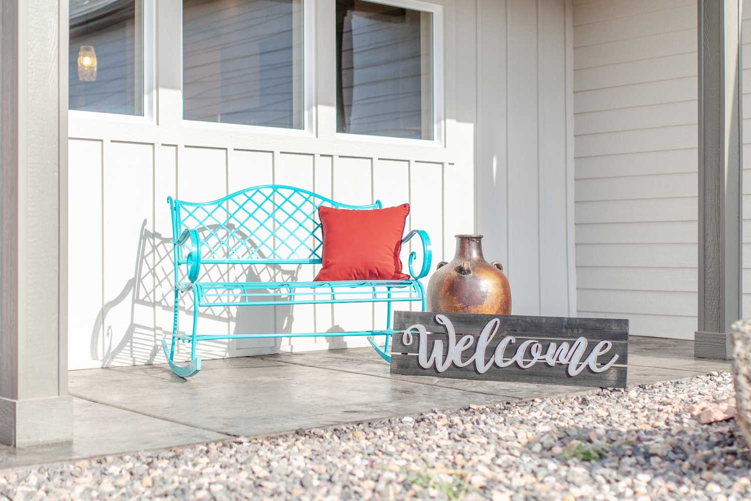 bench on the front porch with a welcome sign made of wood