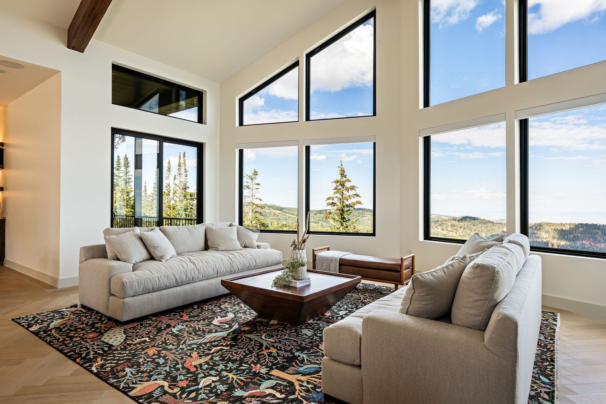 Custom living room with large windows and beautiful view of the mountains in Brain Head, UT by Choice Builders