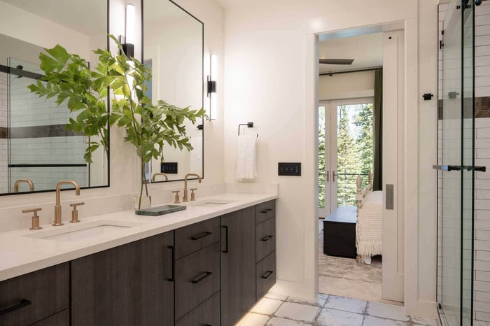 Bathroom double-sink with gold fixtures and quartz countertops in custom home by Choice Builders