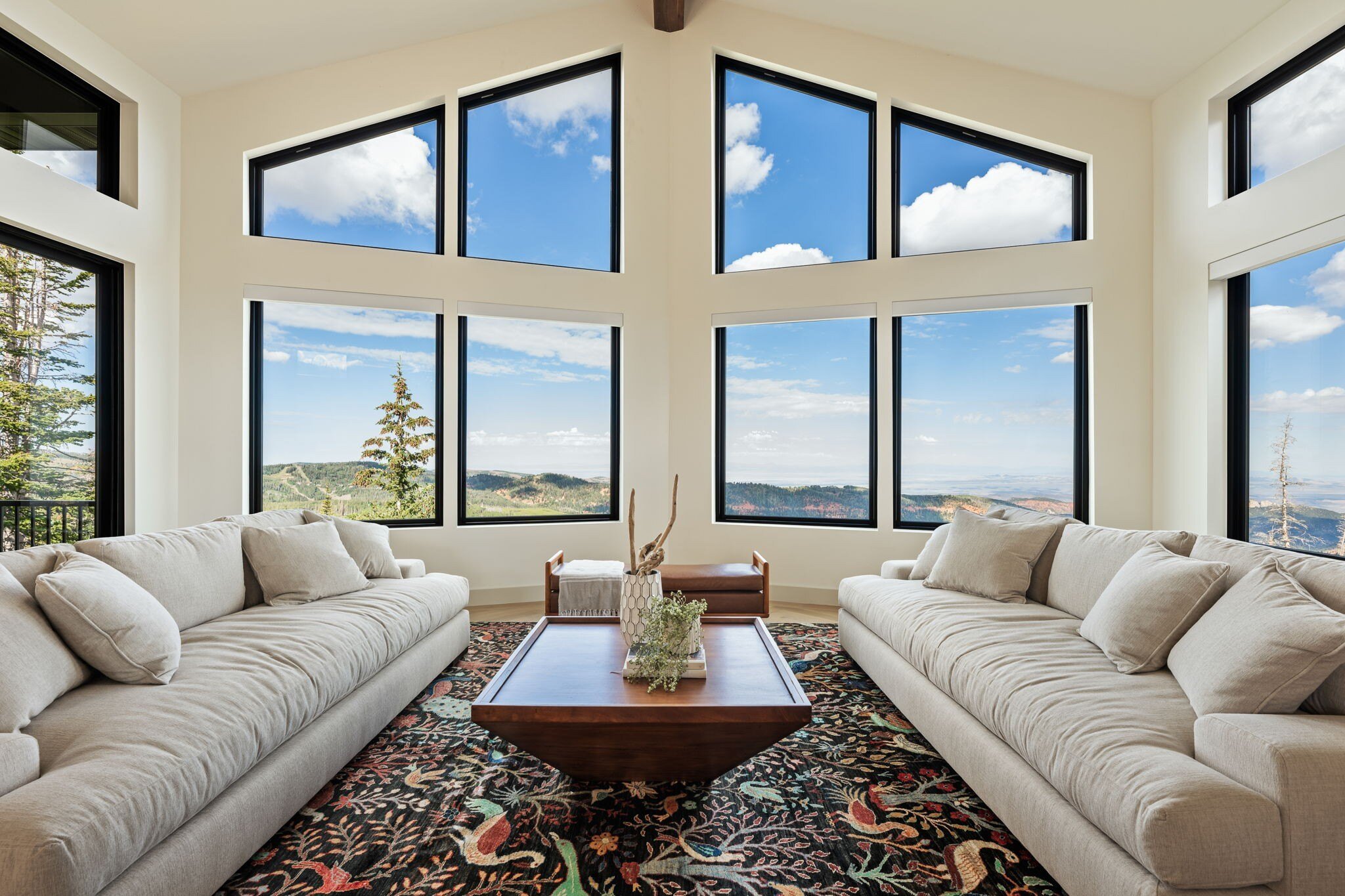 Elegant living room with natural light streaming through expansive windows, designed in a custom mountain lodge home in Brian Head, UT by Choice Builders