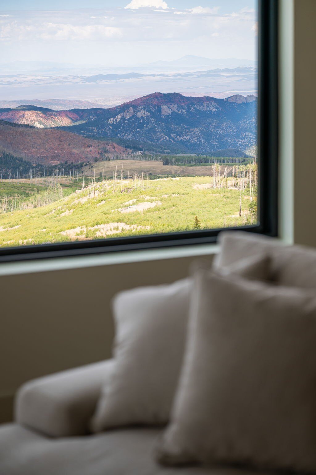 Expansive mountain view seen through a bedroom window in a custom mountain lodge home in Brian Head, UT by Choice Builders