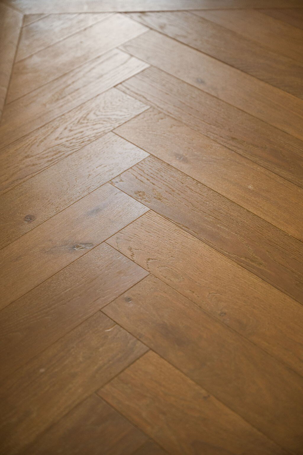 Herringbone-patterned hardwood flooring in a custom mountain lodge home in Brian Head, UT by Choice Builders, emphasizing craftsmanship and natural wood textures