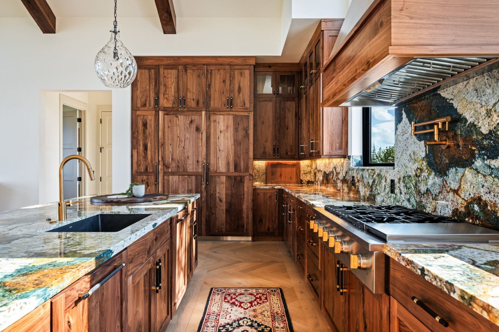 Luxurious kitchen featuring natural wood cabinets and stone countertops in a custom mountain lodge home in Brian Head, UT by Choice Builders