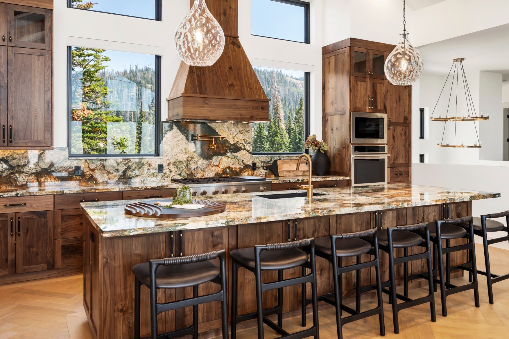 Modern kitchen with granite countertops, natural wood cabinetry, and a scenic backdrop in a custom mountain lodge home in Brian Head, UT by Choice Builders