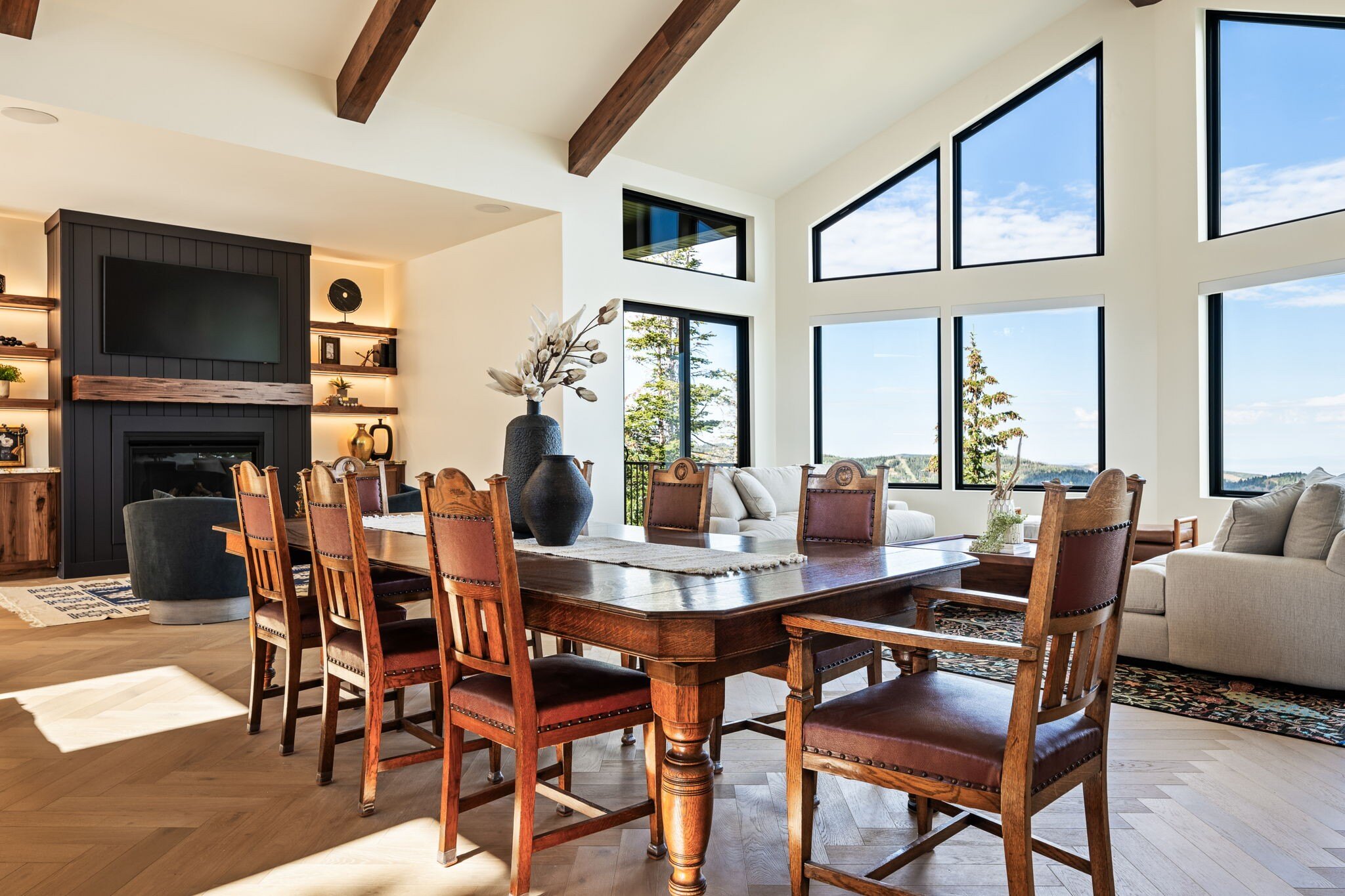 Open-concept dining and living area with wooden furniture and natural mountain views in a custom mountain lodge home in Brian Head, UT by Choice Builders