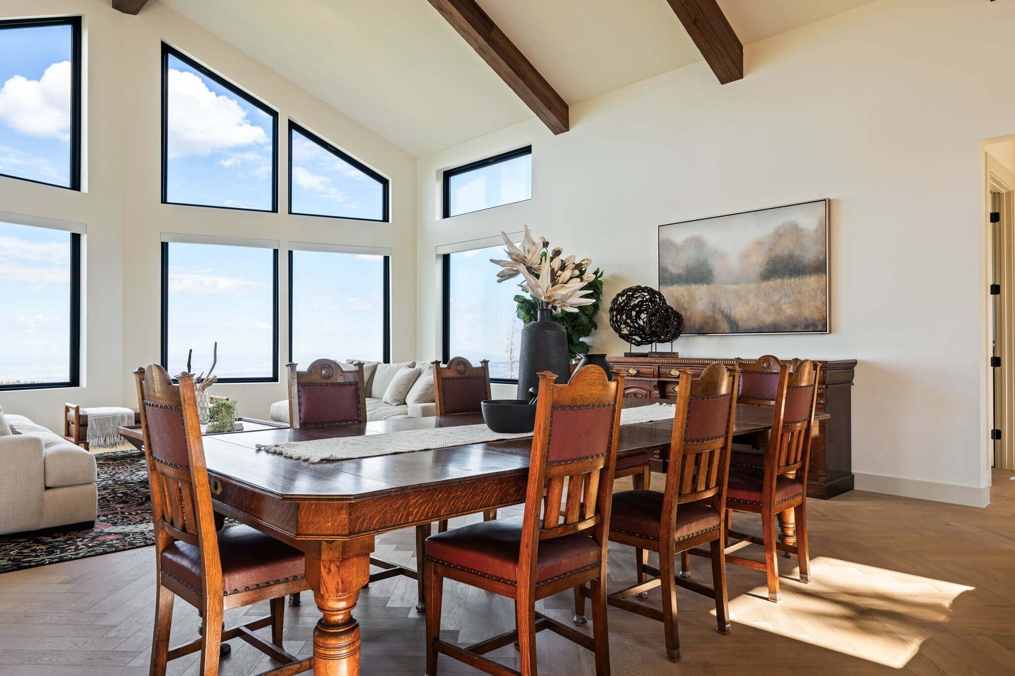 Rustic dining area with high-beamed ceilings and large windows in a custom mountain lodge home in Brian Head, UT by Choice Builders