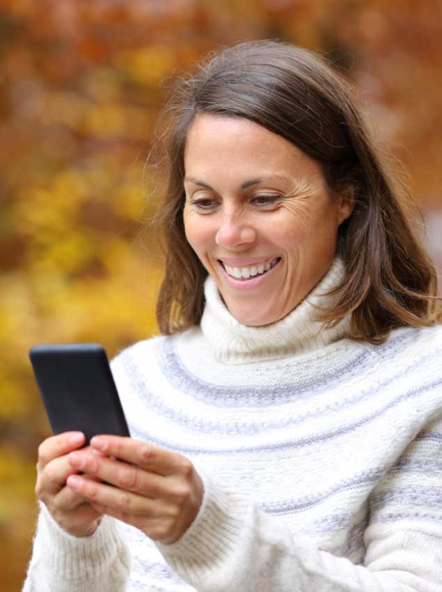 woman using her phone to check home building selections