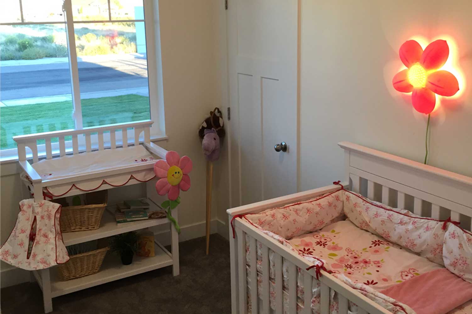 nursery room with changing table and crib and soft orange lighting