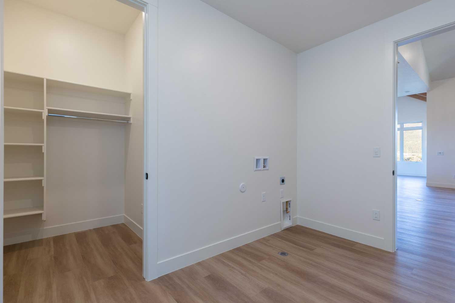 Laundry room hookups and closet with built-in shelving