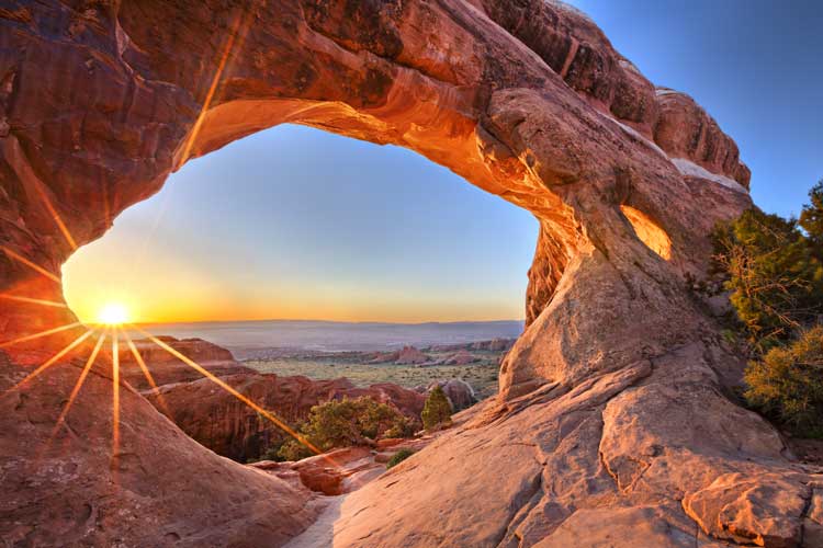 Sunrise view through Partition Arch in Arches National Park
