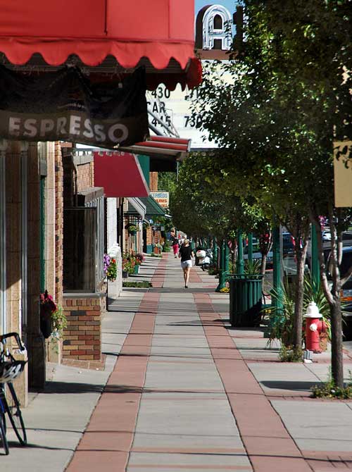 Woman walking along store fronts of downtown Cedar City, Utah